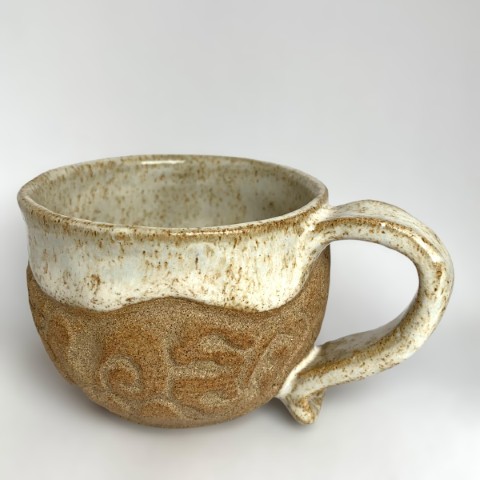 Taza pequeña café pasta expuesta con interior y borde blanco puntos. Labrado